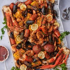 lobsters, corn on the cob and other seafood are served on a platter