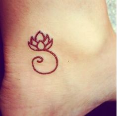 a small tattoo on the ankle of a woman's foot with a red flower