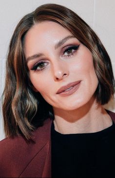 a woman with long hair wearing a burgundy blazer