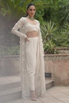 Ivory open-front jacket with beads, pearls and 3D floral embellishment. Comes with sleeveless crop top and co-ordinating crepe pants.
Components:3
Pattern:Embellishment
Type of Work:Pearl, Beads and 3D floral motifs
Neckline:Round
Sleeve Length:Jacket: Full and Crop Top: Sleeveless
Fabric:Organza and Crepe
Color:White
Other Details:
Crop top with bead drops
Pleated pants with embellished hems
Open front cape
Occasion:Destination Wedding - Aza Fashions Indian Outfits Modern, Pengantin India, Trendy Outfits Indian, Lehenga Designs Simple, Gaun Fashion, Traditional Indian Dress, Indian Dresses Traditional, Traditional Indian Outfits, Kiara Advani