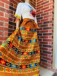 "Slip into easy sassiness with this African Print maxi skirt. Has pockets. This comfortable skirt has an elastic waistband with 2 straps and should fit up to a 2X waist. Length is 42\". 100% cotton. Hand wash in cold water. Warm iron." Kente Skirt, African Print Pants, African Print Maxi Skirt, Styles Dress, Comfortable Skirts, Print Maxi Skirt, Cotton Slip, Classy Design, Collared Shirt Dress