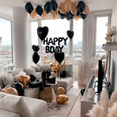 a living room filled with furniture and balloons in the shape of heart shaped balloons that say happy birthday