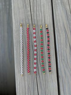 four beaded bracelets sitting on top of a wooden table