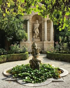 a fountain in the middle of a garden surrounded by greenery