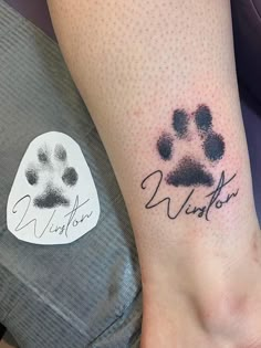 a person with a tattoo on their foot that has a dog's paw and name