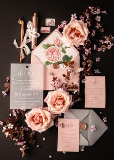 the wedding stationery is laid out with pink flowers