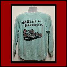 Vintage printed sweatshirt "Harley-Davidson".  Vintage seafoam green sweatshirt with a printed image of skulls in the letters "Harley-Davidson" and image of two Harley rider on their bike in black & red. The shirt has a ribbed neckline and cuffs. The garment is a cotton blend and is soft and well worn. The sweatshirt has no label. PLEASE NOTE: See measurements below for correct fit as sweatshirt no longer has a size tag. MEASUREMENTS: (All measurements were taken lying flat) Shoulders - 19" (measured on back of the shirt from seam to seam) 23" (measured from pit to pit) Sleeve-22" (measured from shoulder to cuff) Sleeve-20" (measured from pit to cuff) Length -26" (measured on top of shirt collar to the bottom hem) Casual Long Sleeve T-shirt For Motorcycling, Sports Sweatshirt With Screen Print, Long Sleeve, Green Sweatshirt, Ribbed Neckline, Seafoam Green, Shirt Collar, Cuff Sleeves, Printed Sweatshirts, Vintage Prints