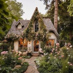 a small house with lots of flowers around it