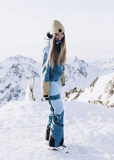 a woman standing on top of a snow covered slope