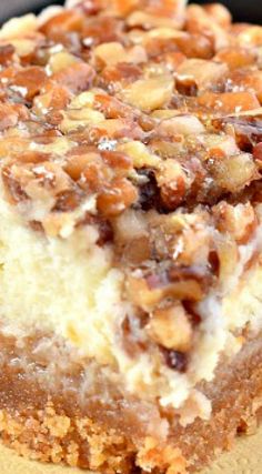 a close up of a piece of cake on a plate with nuts and cream topping