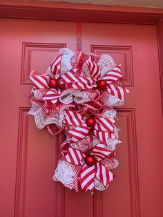 a red and white wreath hanging on the front door