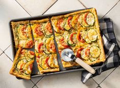 a pan filled with vegetable quiche on top of a table