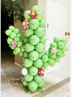 a green balloon sculpture with flowers on it