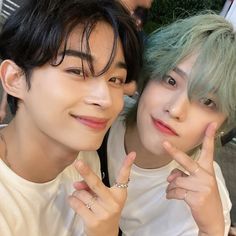 two young men posing for the camera with green hair