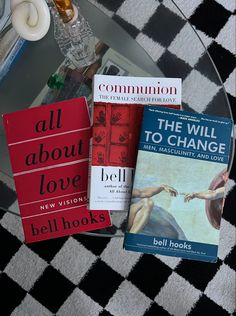 three books sitting on top of a glass table