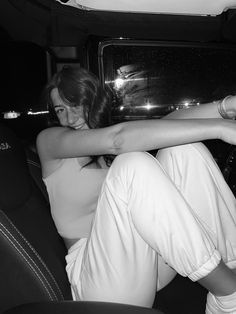 a woman sitting in the back seat of a car with her arm wrapped around another person's shoulder