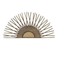 a wooden sculpture with large spikes on it's face and the sun in the background