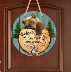 a bear hanging on a door with the words welcome to our most of the world