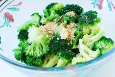 a bowl filled with broccoli on top of a table