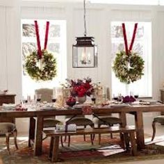 a dining room table decorated for christmas with wreaths