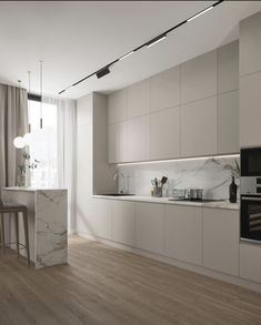 a modern kitchen with white cabinets and marble counter tops, along with an island in the middle