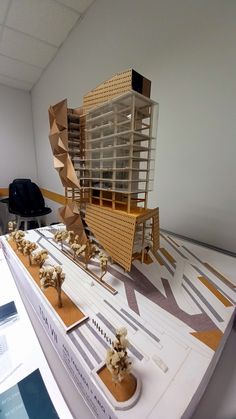 a model of a building on display in a room with white walls and flooring