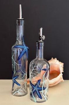 two glass bottles with starfish designs on them