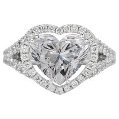 a heart shaped diamond ring set in white gold with diamonds around the band and shoulders