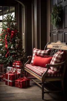 a christmas tree with red and white plaid pillows next to a couch covered in presents