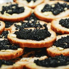 black cavias are arranged on toasted bread and placed on a plate with the words t & e