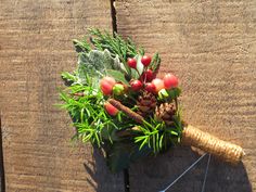 a bouquet of flowers on top of a piece of wood next to a wire fence