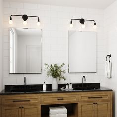 a bathroom with double sinks and two mirrors