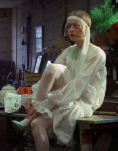 a woman sitting on top of a wooden table