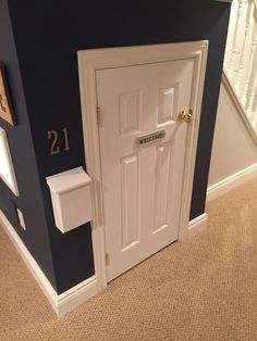 an open door with the words playhouse under the stairs on it, and a white toilet paper dispenser