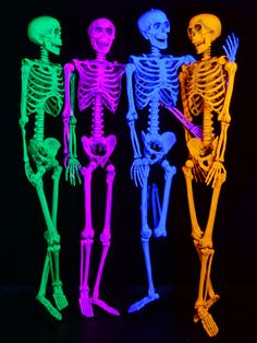 three neon colored skeletons standing next to each other