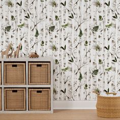 the wallpaper in this room is decorated with white birch trees and green leaves, along with wicker baskets