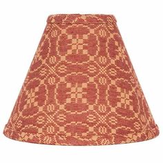 a red lamp shade with an intricate pattern on the top and bottom, sitting against a white background