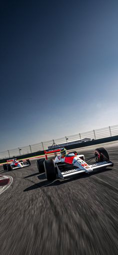 two racing cars on a race track with motion blurry from the front and back