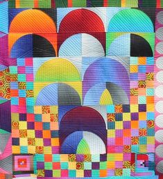 a colorful quilt with many different colors and shapes on it's sides, including an arch