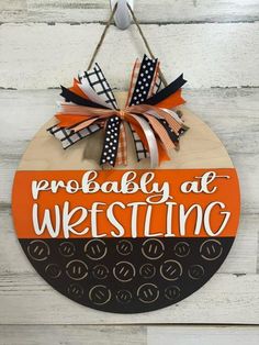 a wooden sign that says probably at westing hanging on a white wood wall with orange and black ribbon