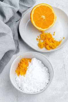 two white plates with orange slices and powdered sugar