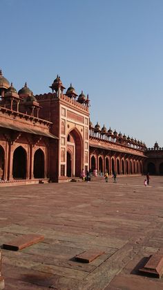 an old building with people walking around it