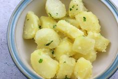 a bowl filled with cooked potatoes on top of a table