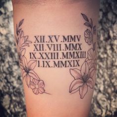 a woman's lower leg with flowers and roman numerals tattoo on it