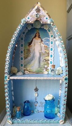 a blue shelf with an image of the virgin mary on it and other items around it