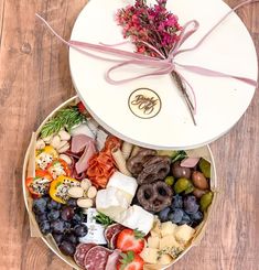 two bowls filled with assorted fruits and cheeses on top of a wooden table