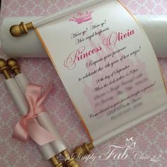 a pink and white diploma laying on top of a table next to a roll of paper