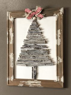 a christmas tree made out of old newspaper is hanging on the wall in a frame