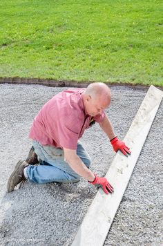 a man in red shirt and gloves working on concrete