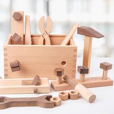 wooden toys are arranged in a box on a table